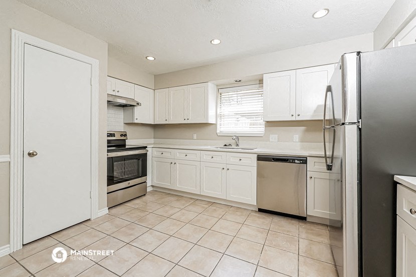a white kitchen with stainless steel appliances and white cabinets