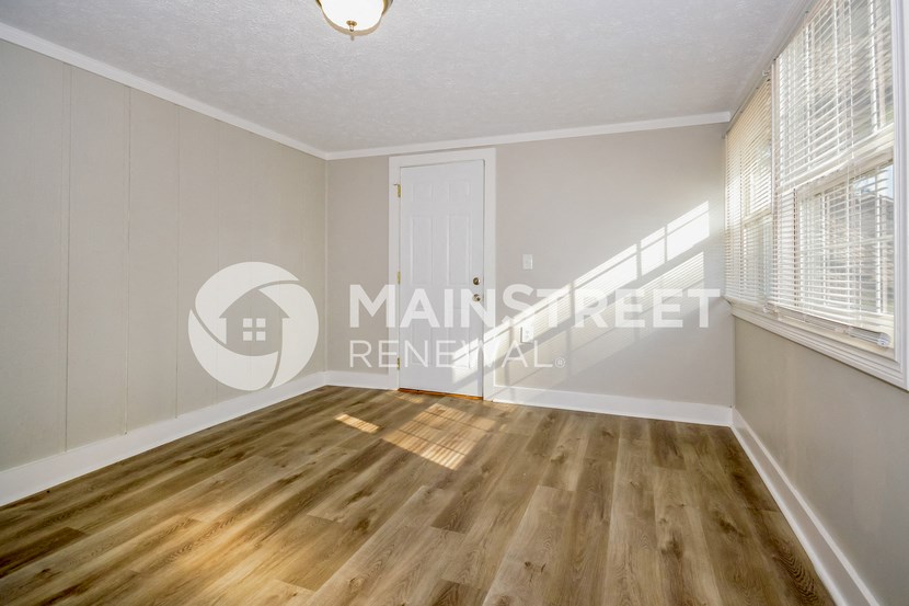 a renovated living room with wood floors and white walls