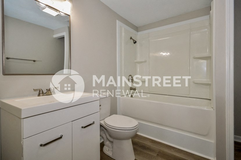 a renovated bathroom with white cabinets and a sink and a toilet
