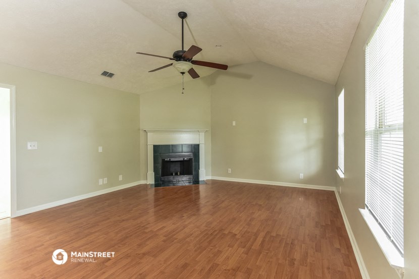 the living room with wood flooring and a fireplace