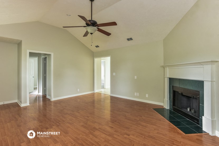 the living room with fireplace and ceiling fan