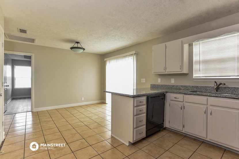 a kitchen with white cabinets and a sink and a counter top