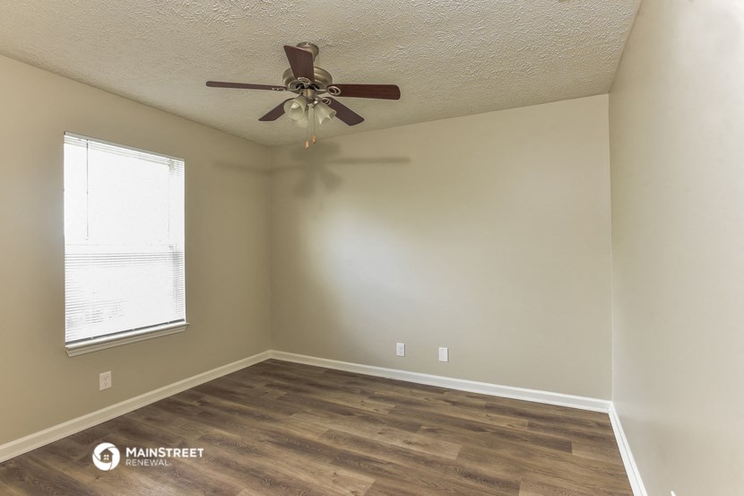 a bedroom with a ceiling fan and a window