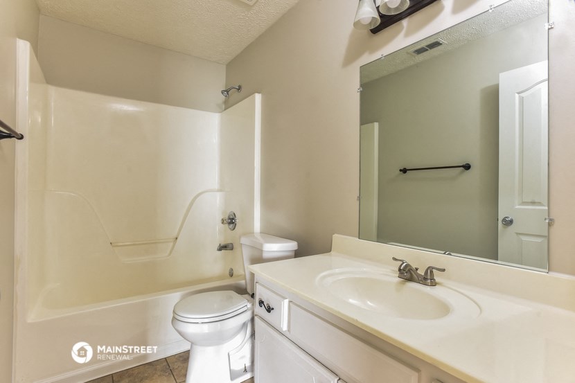 a bathroom with a sink toilet and a mirror