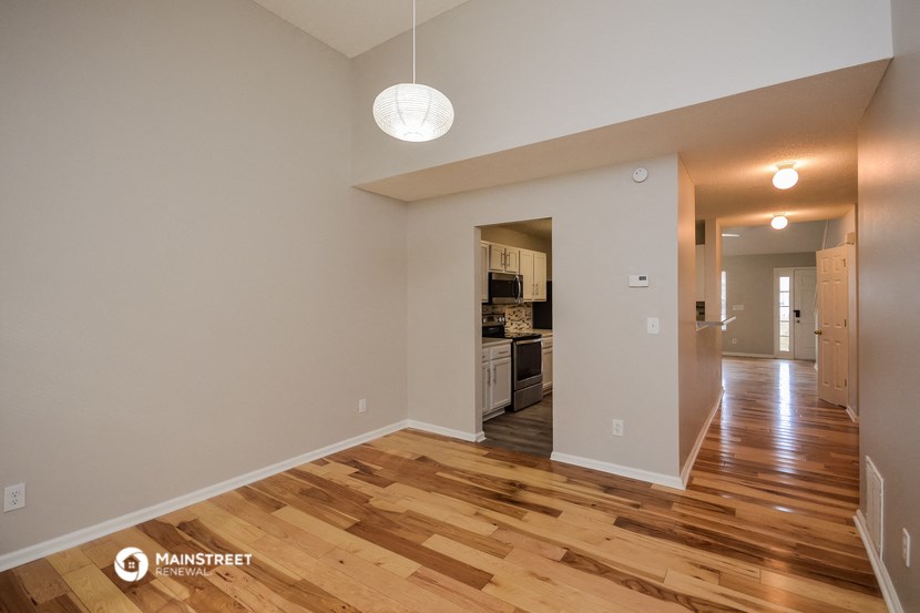 a living room with a hard wood floor and a kitchen