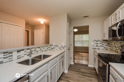 a large kitchen with white cabinets and a sink