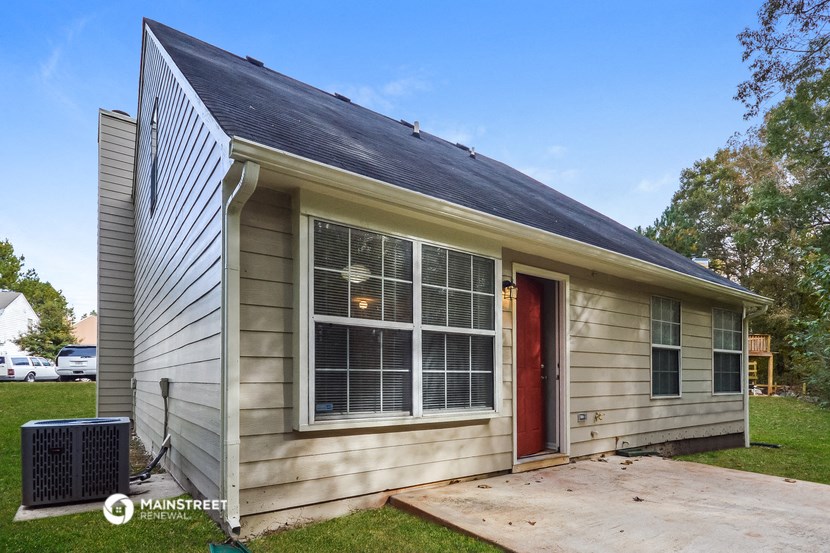 the front of a small house with a red door
