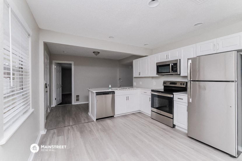 a white kitchen with stainless steel appliances and white cabinets