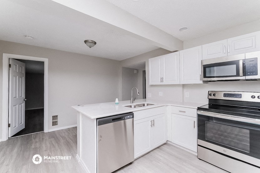 a white kitchen with stainless steel appliances and white cabinets