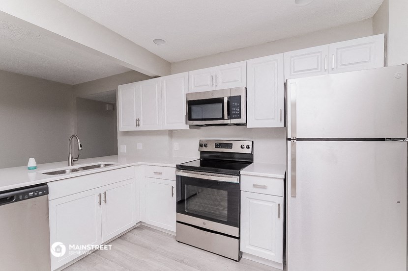 a kitchen with white cabinets and stainless steel appliances