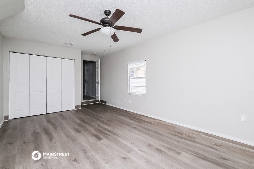 the living room of an empty house with a ceiling fan
