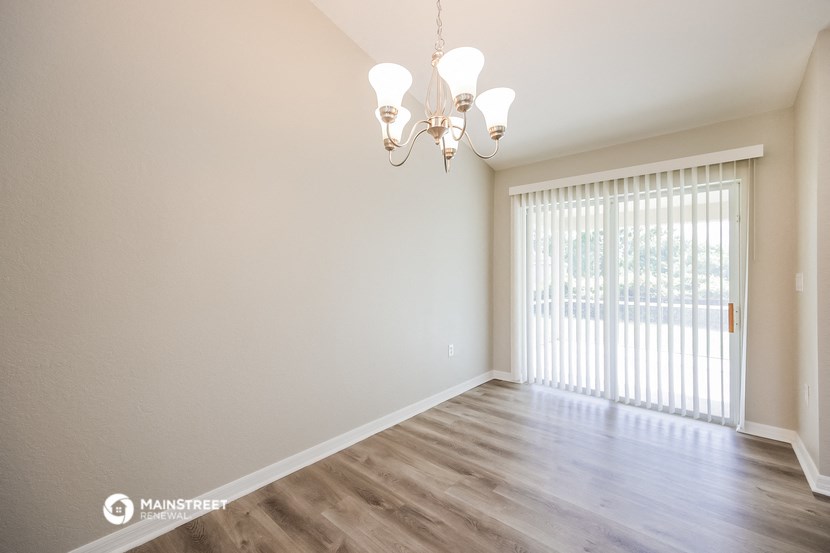 a living room with a large window and a chandelier