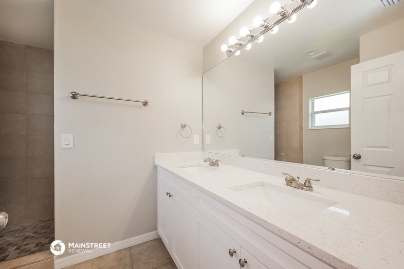 a white bathroom with a sink and a mirror
