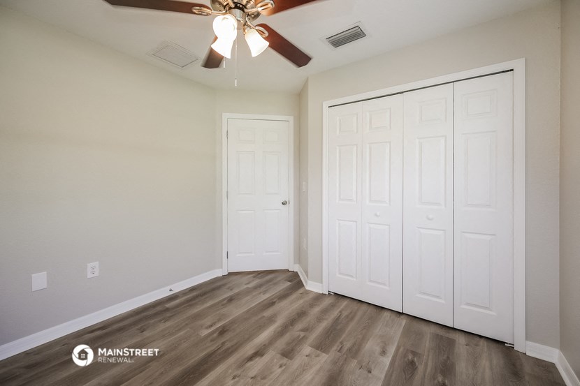 a bedroom with two closets and a ceiling fan