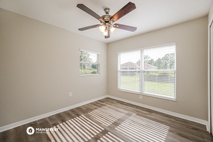 a living room with a ceiling fan and a window
