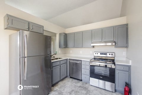 the kitchen of an apartment with stainless steel appliances and gray cabinets