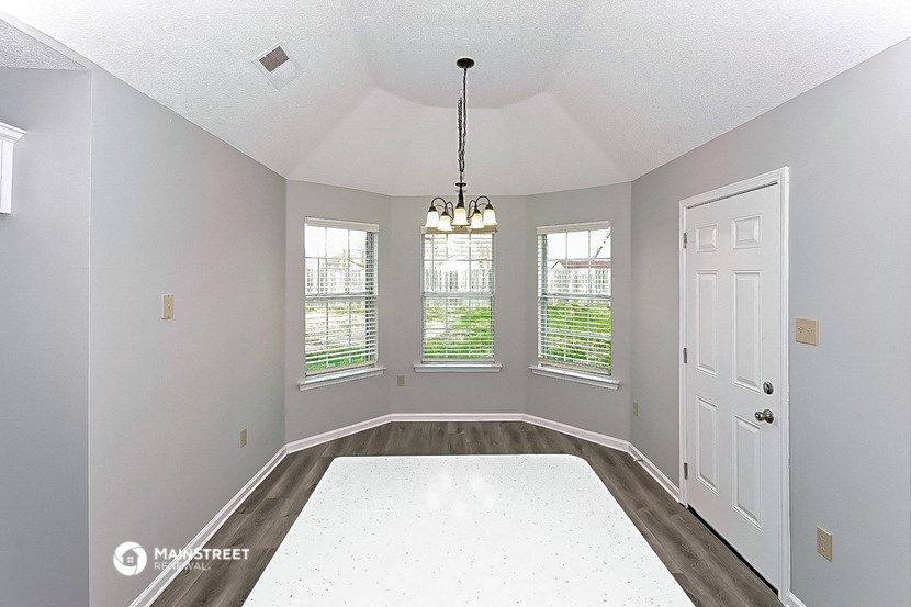 an empty living room with a white rug and a white door