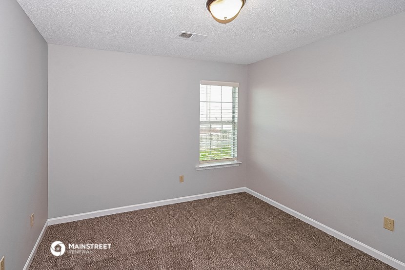 an empty room with carpet and a window