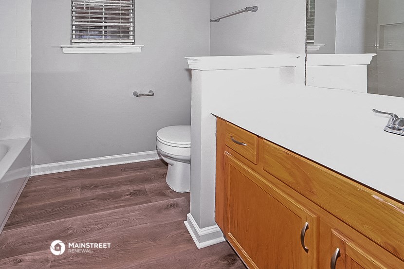 a bathroom with a toilet and a sink and a mirror