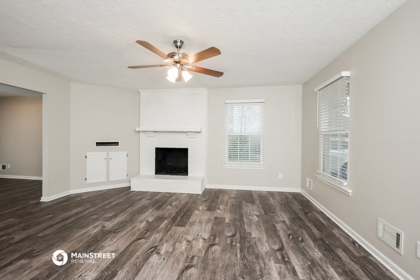 the living room of our studio apartment atrium with fireplace and ceiling fan