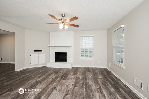 the living room of our studio apartment atrium with fireplace and ceiling fan