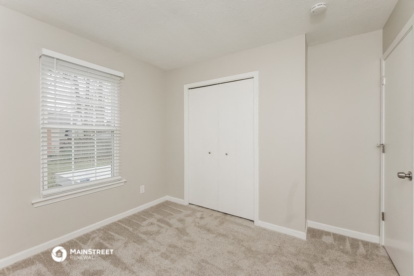 a bedroom with a closet and a window and a door