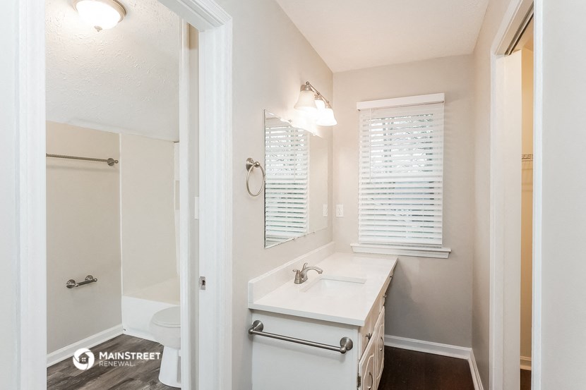 a bathroom with a sink and a shower and a mirror
