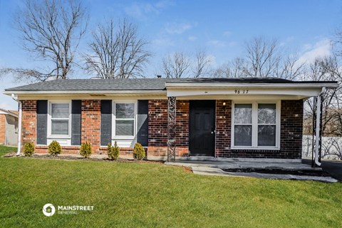 the front of a brick house with a black door