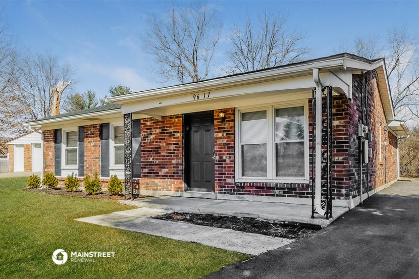a brick house with a porch and a black door