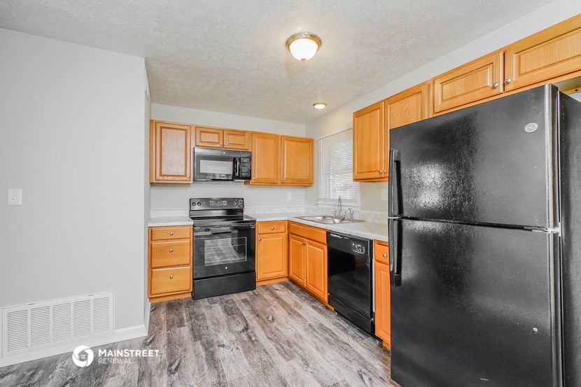 a kitchen with black appliances and wooden cabinets