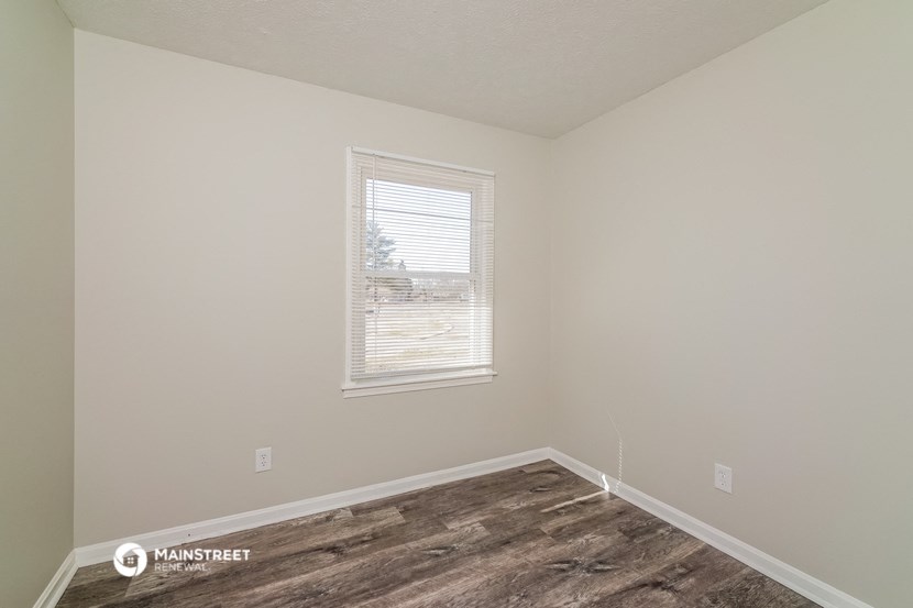 the living room of a house with a wood floor and a window
