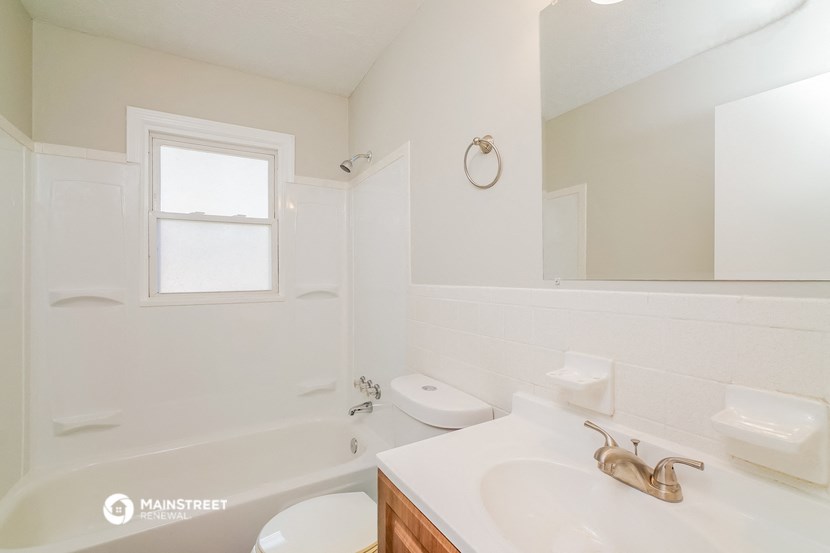 a bathroom with a tub and a sink and a mirror