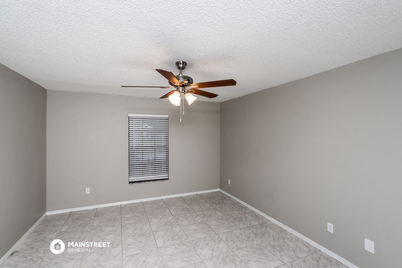 the living room has a ceiling fan and a tiled floor