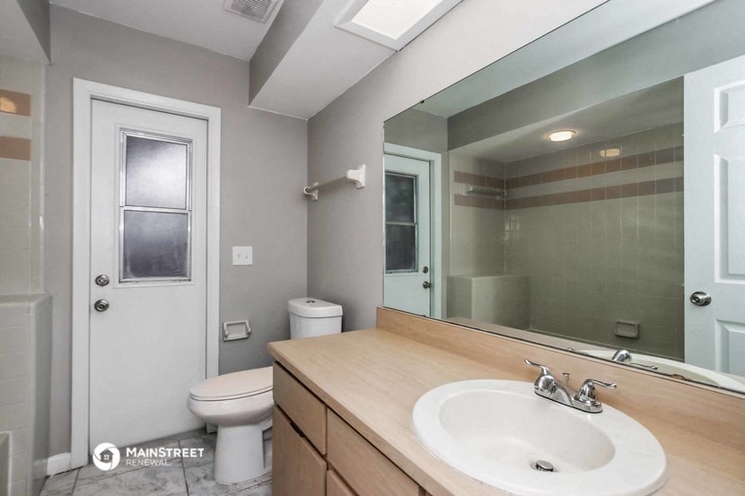 a bathroom with a sink and a mirror and a toilet
