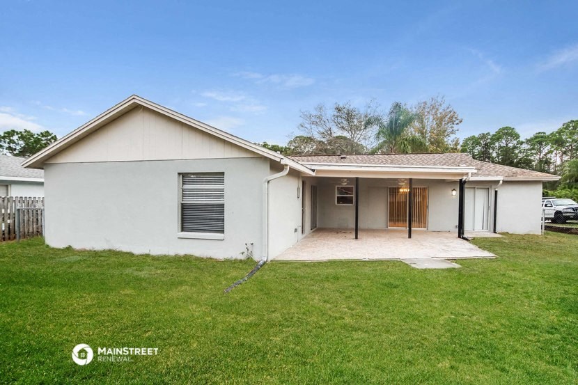 a white house with a grass yard and a garage
