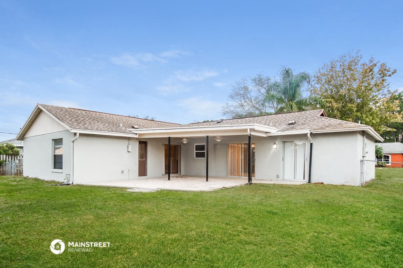 a white house with a grass yard and a garage