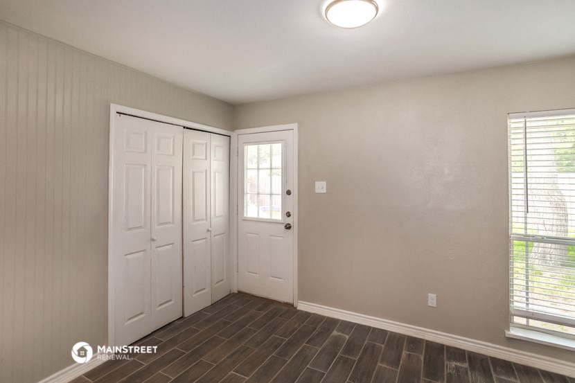 the living room of a house with white doors and a window