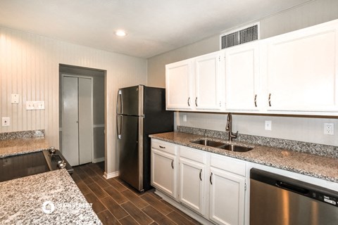 a kitchen with white cabinets and a stainless steel refrigerator