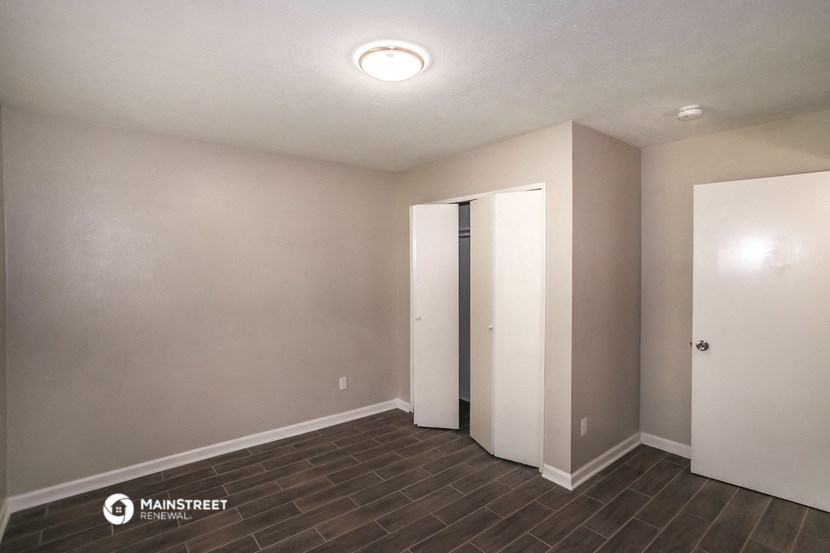 the living room of an empty apartment with two doors