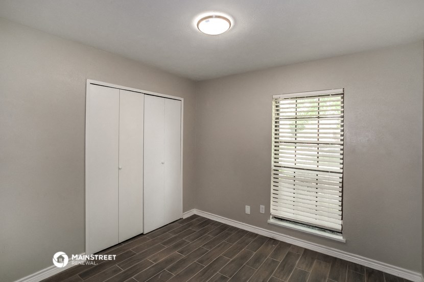 the bedroom of a house with a closet and a window