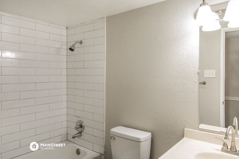 a bathroom with a toilet and a sink and a shower