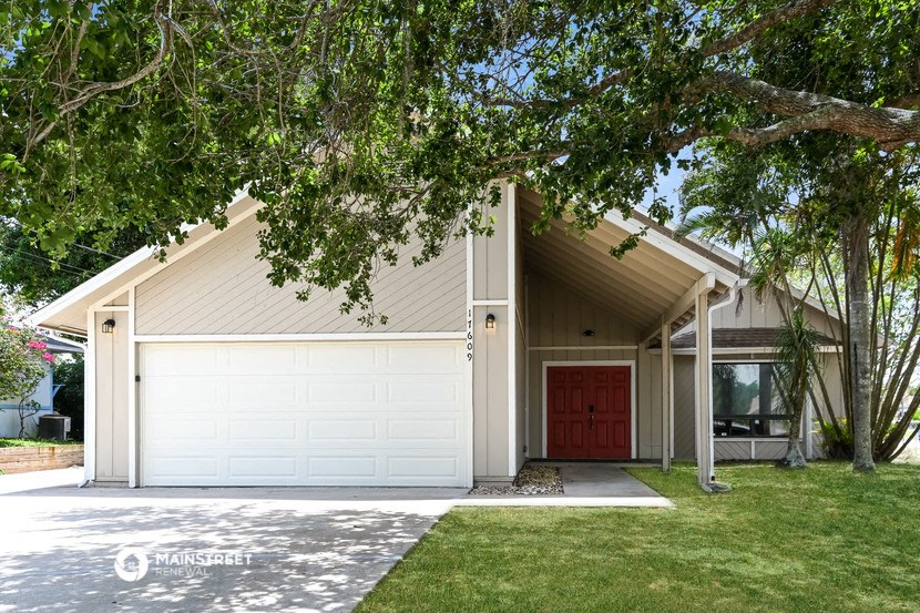 a white garage with a red door on the side of a house