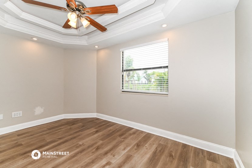 a living room with a ceiling fan and a window