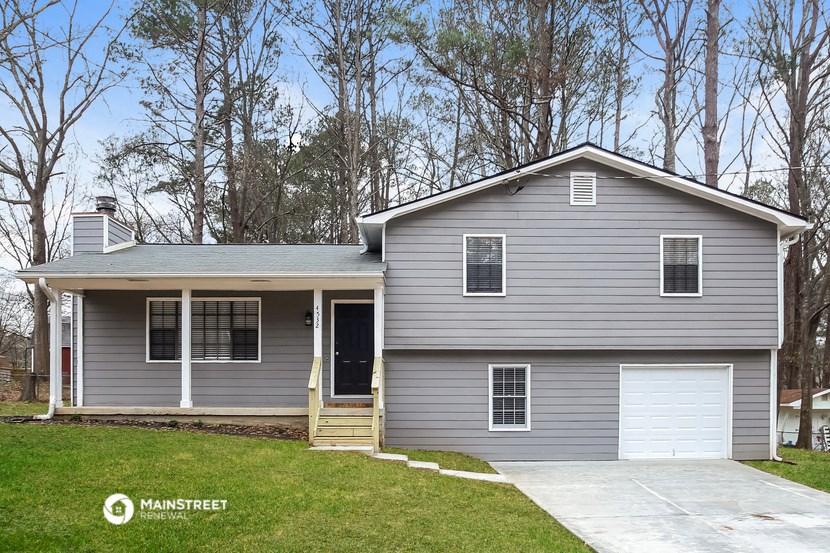 a gray house with a white garage door and a lawn