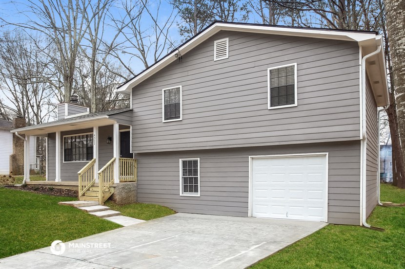 a gray house with a white garage door and a driveway