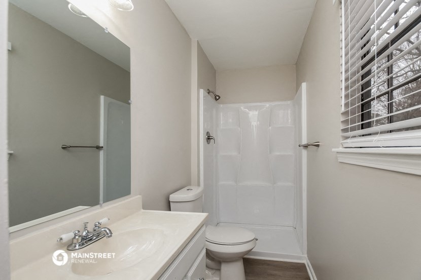 a white bathroom with a shower toilet and sink