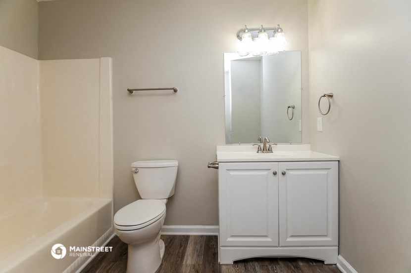 a bathroom with a toilet and a sink and a mirror