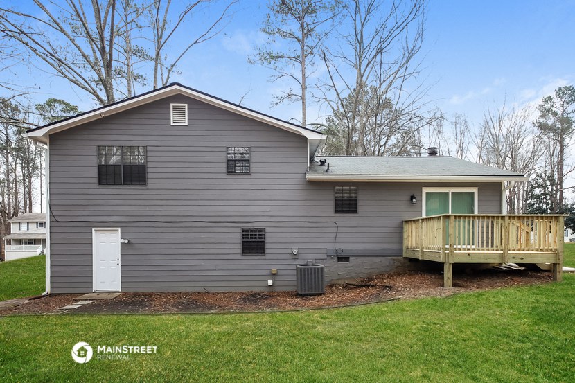 a gray house with a deck on the side of it