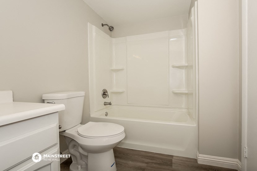a white bathroom with a toilet and a tub