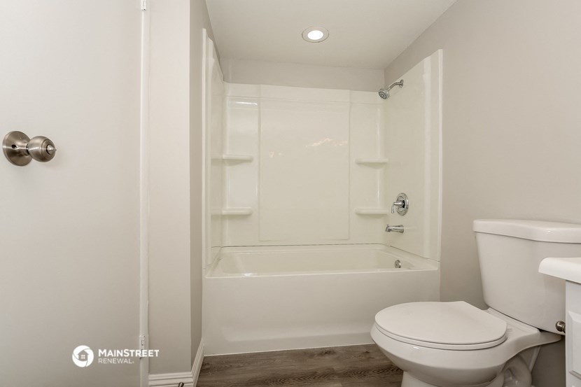 a bathroom with a toilet and a tub and a shower